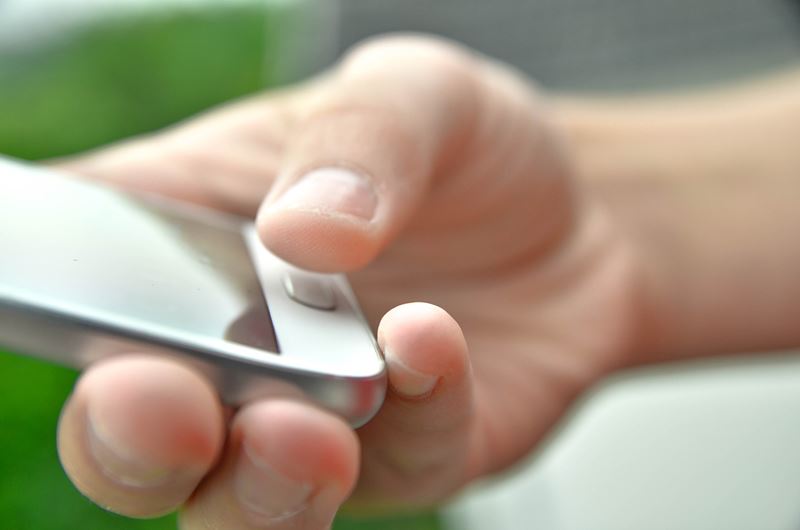 A closeup of a man holding a phone